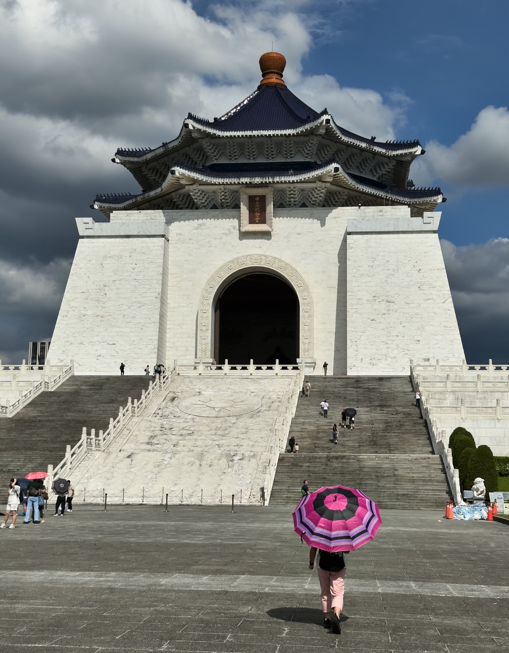 A person with an umbrella walks towards the Chiang Kai-Shek Memorial Hall in Taipei, Taiwan
